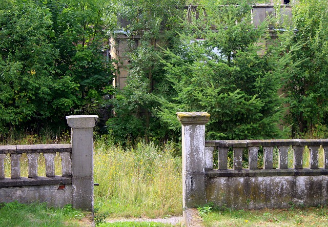 betonový plot s otevřenou brankou